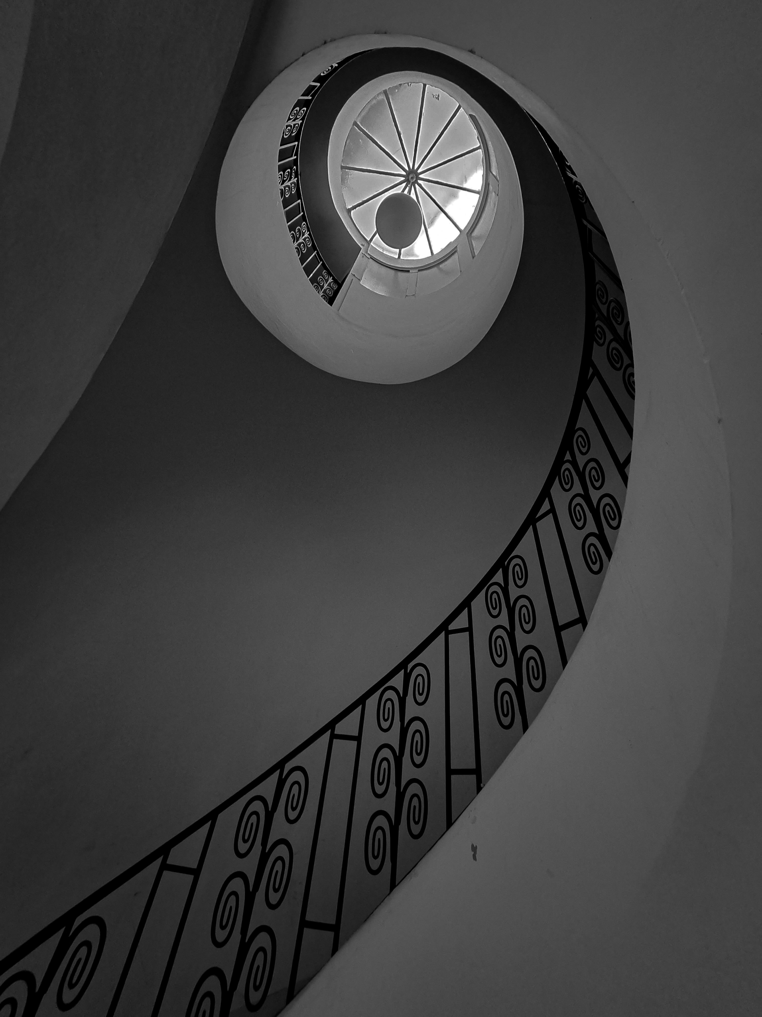 Spirale -- Les spirales et l'architecture m'ont toujours fasciné, et cet escalier en colimaçon combine parfaitement ces deux passions. J'adore la manière dont les courbes de cette escalier de Munich créent une harmonie visuelle unique.