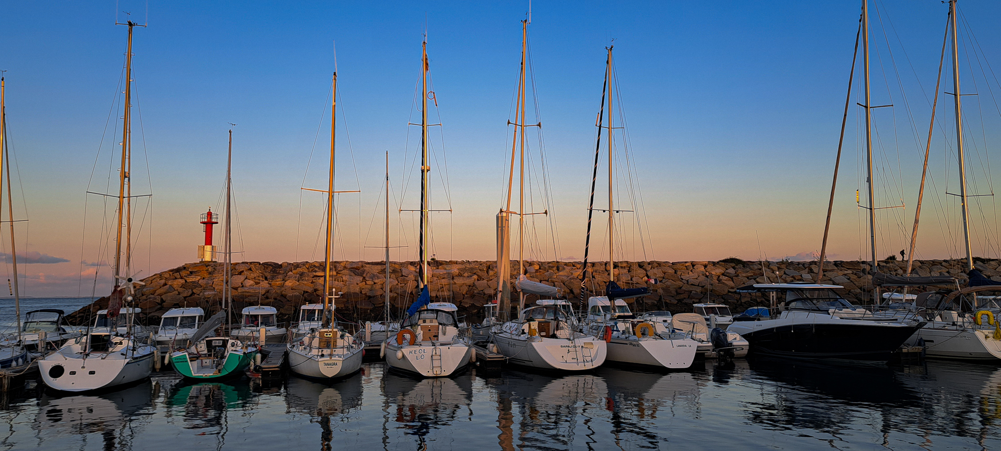 Binic -- Un joli coucher de soleil embrassant le port de Binic, en Bretagne, pendant que les bateaux rentrent doucement au port. Les rayons dorés du soleil créent une atmosphère chaleureuse et apaisante, illuminant le ciel et les eaux calmes du port. C'est un moment empreint de tranquillité et de sérénité, où l'on peut contempler la beauté naturelle de la Bretagne et ressentir l'harmonie entre l'homme et la mer. Cette image capture l'instant fugace où la journée laisse place à la douce quiétude de la soirée, offrant un spectacle magique à ceux qui prennent le temps de l'admirer.